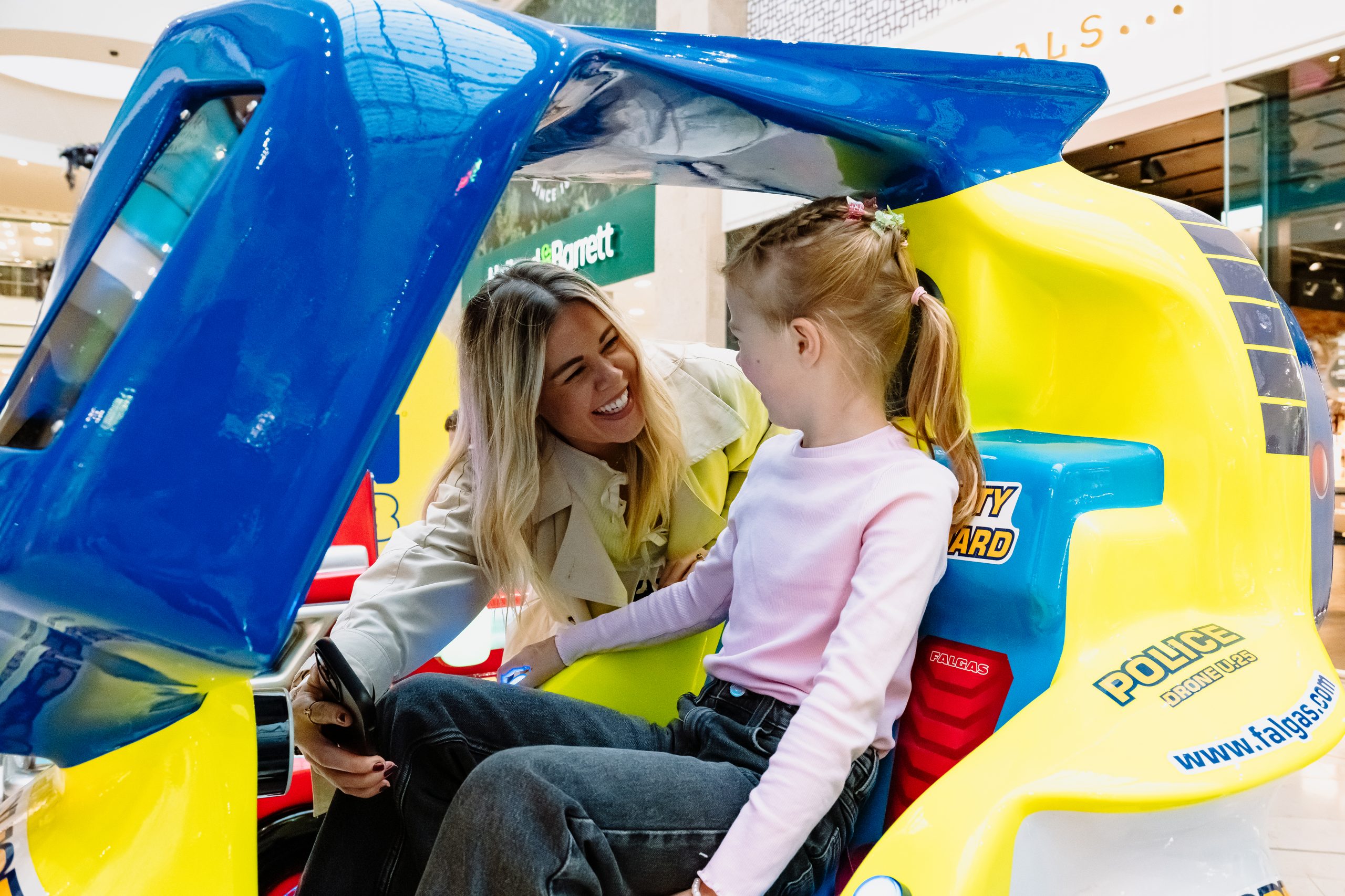 Parent and child having fun and paying for FunHub kiddie ride